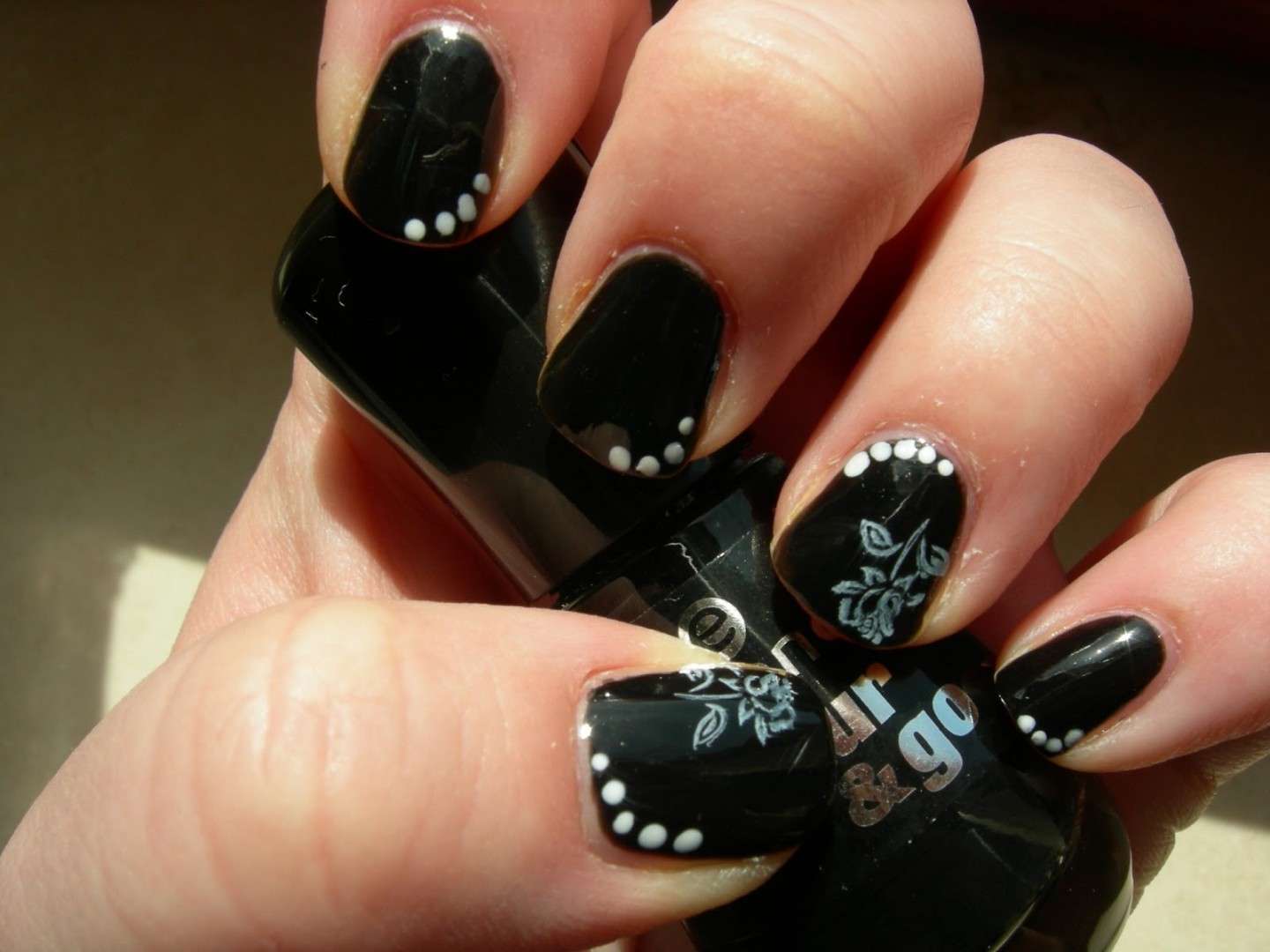 Nail art nera con fiori bianchi