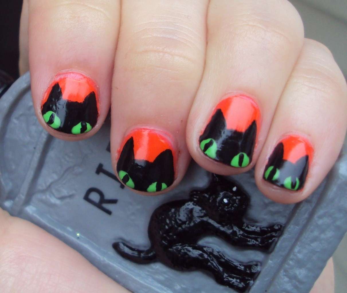 Nail art arancione e gatto nero