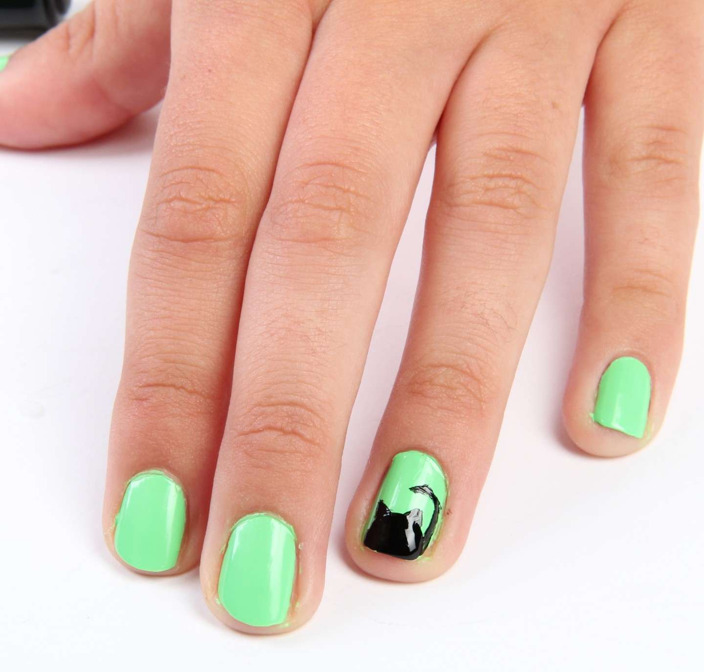 Nail art verde con gatto nero