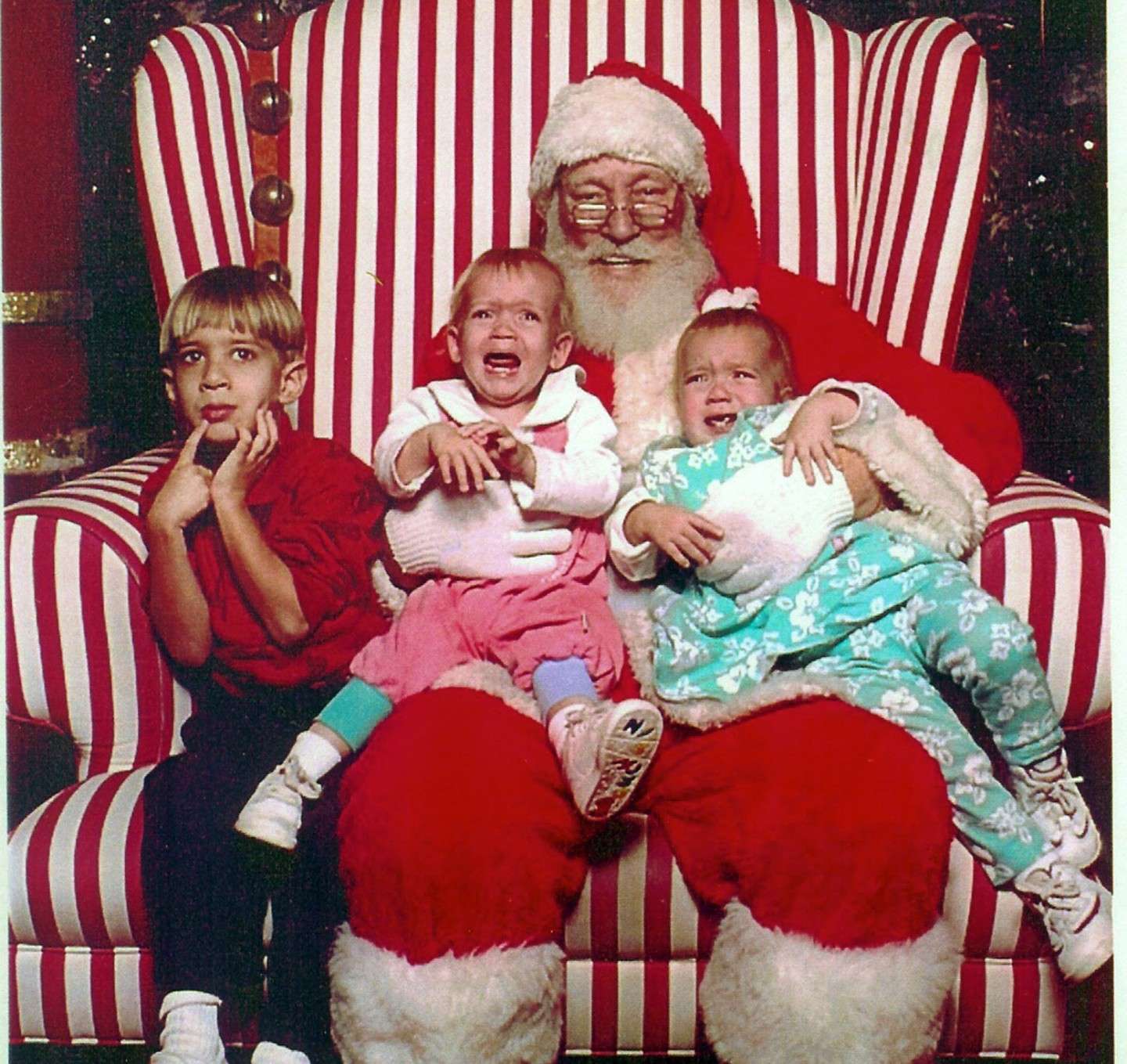 Bambini spaventati sulle ginocchia di Babbo Natale
