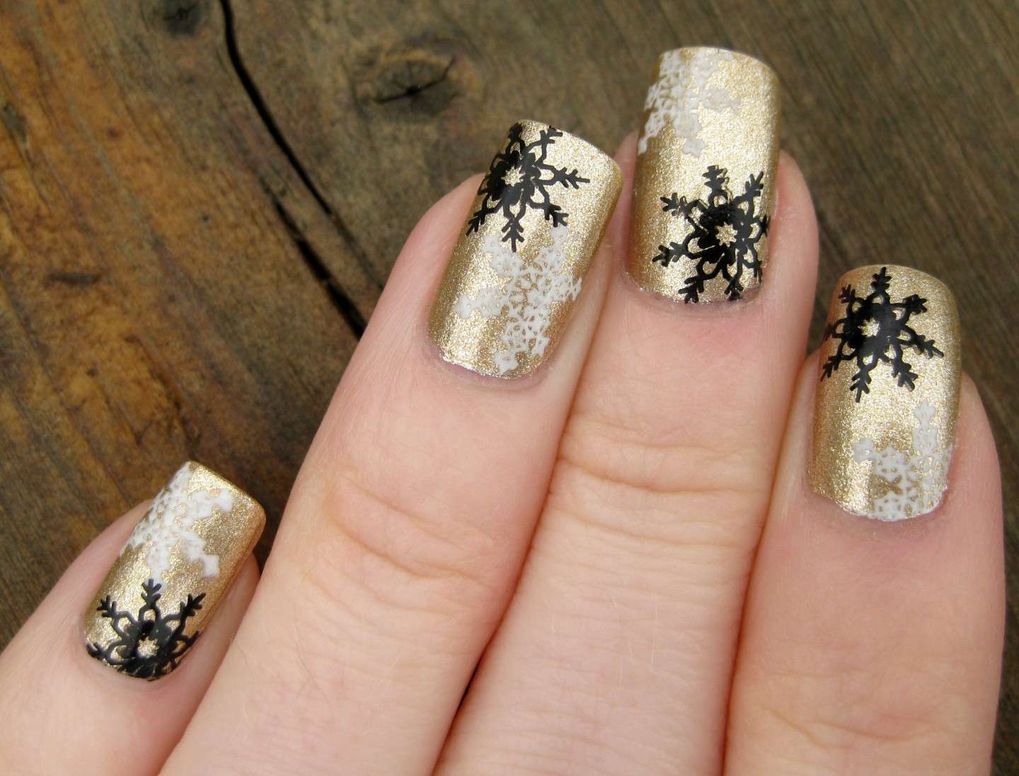 Nail art dorata con fiocchi di neve