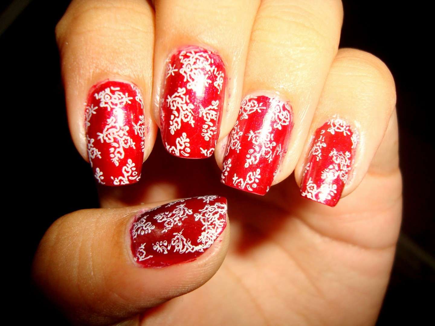 Nail art rossa con decorazioni bianche