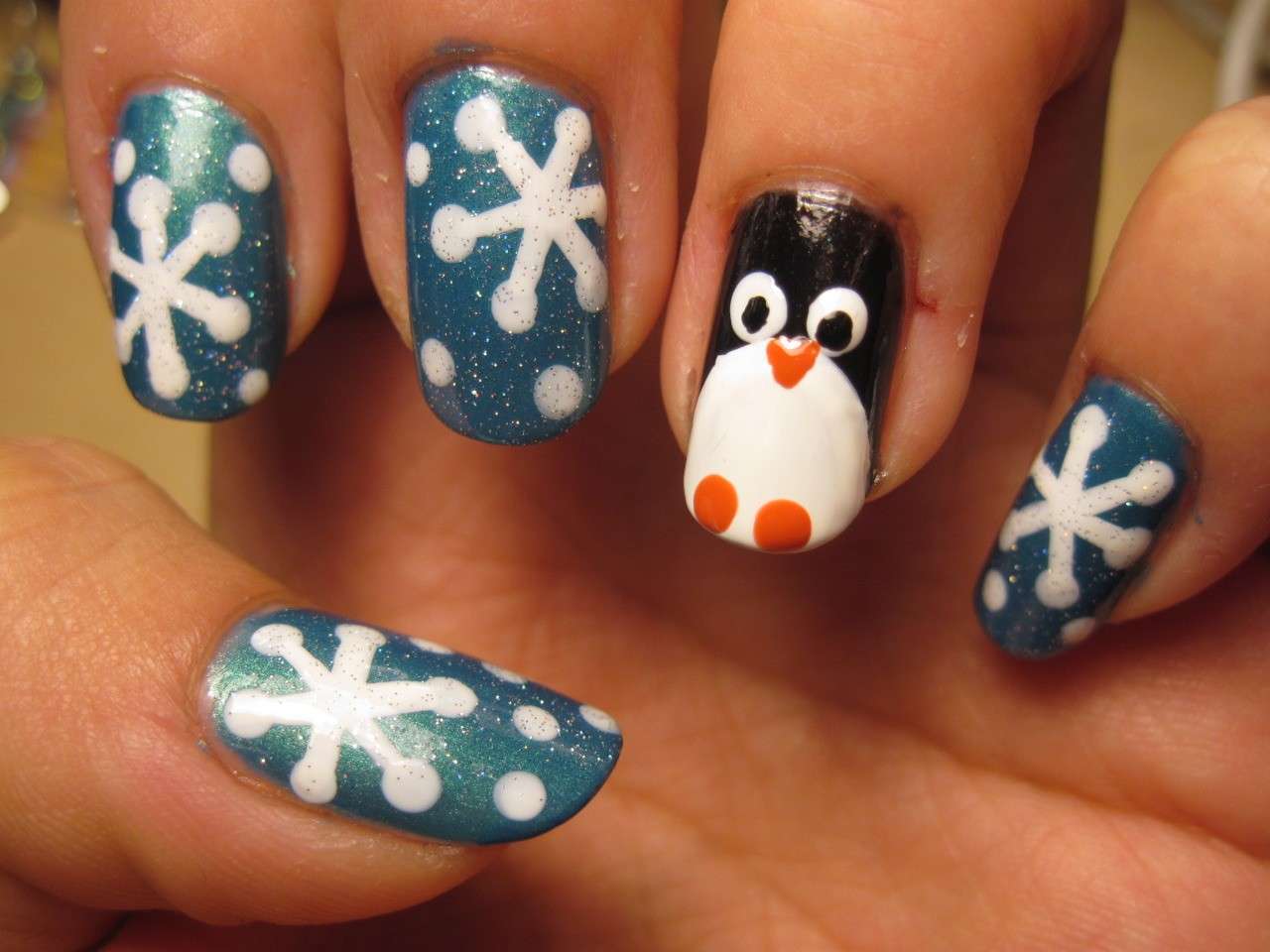 Nail art invernale con fiocchi di neve e pinguino
