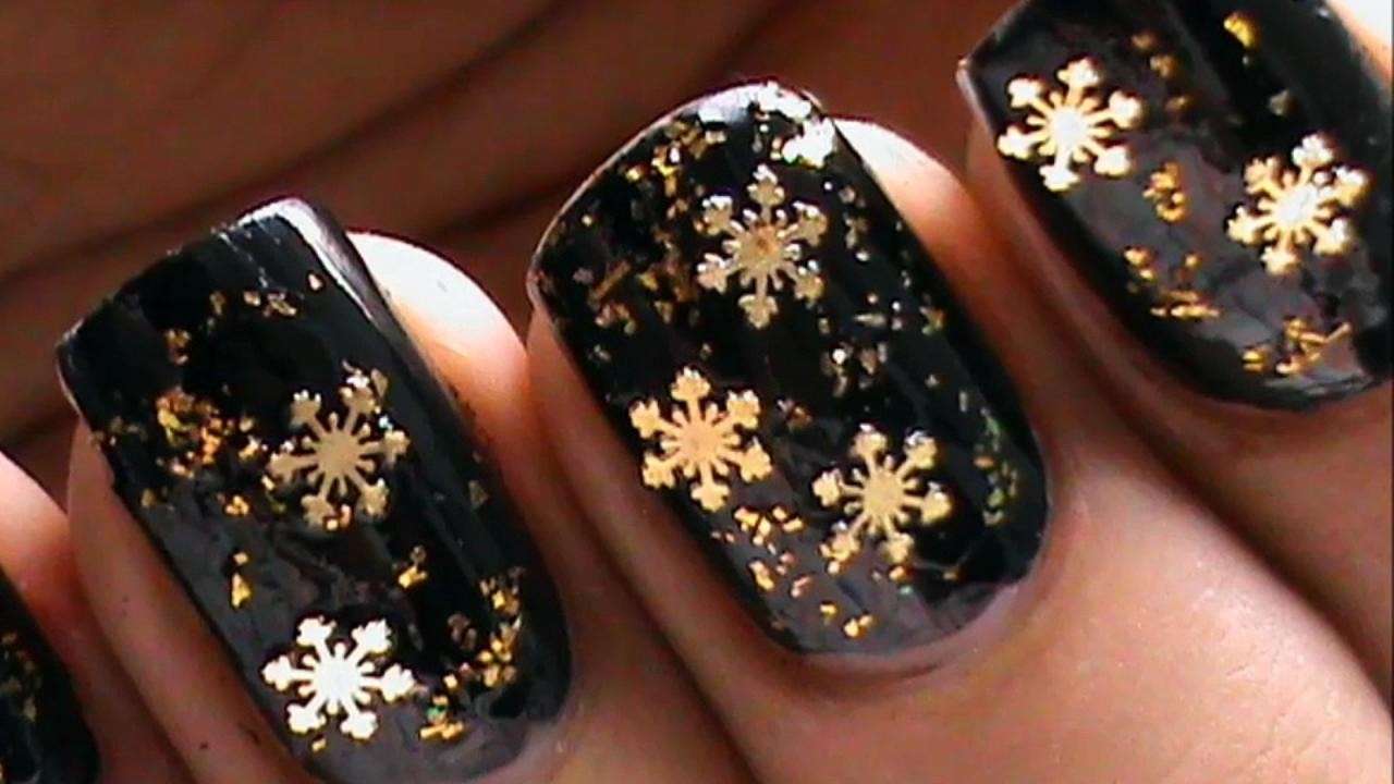Nail art nera con fiocchi di neve oro