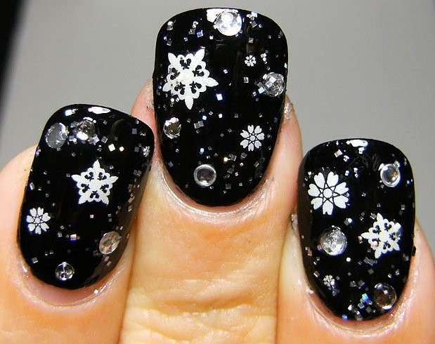 Nail art nera con strass e fiocchi di neve