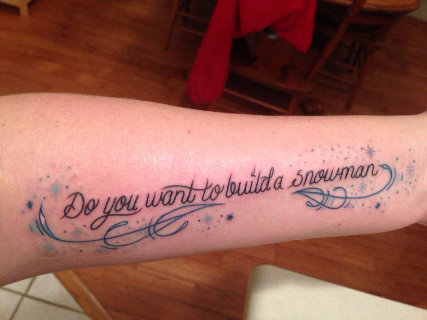 Tatuaggio con scritta "Do you want to build a snowman"