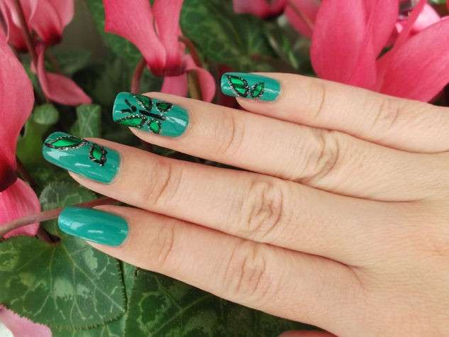 Nail art verde con farfalle glitterate
