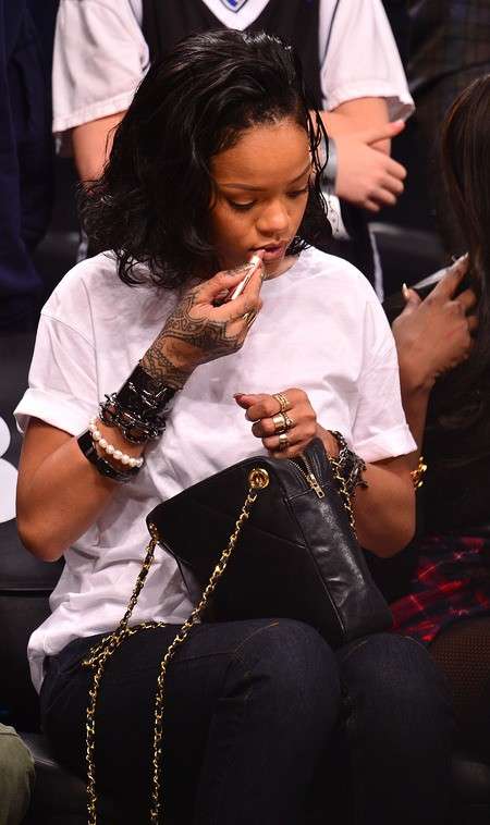 Rihanna con la t-shirt bianca e la tracolla
