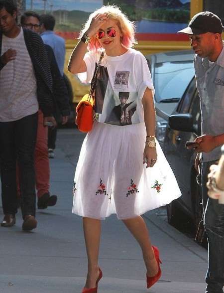 Rita Ora con t-shirt bianca e gonna svasata