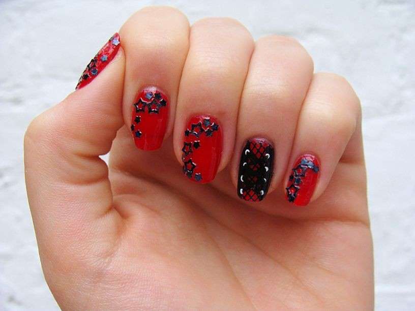 Nail art rossa con stelline nere