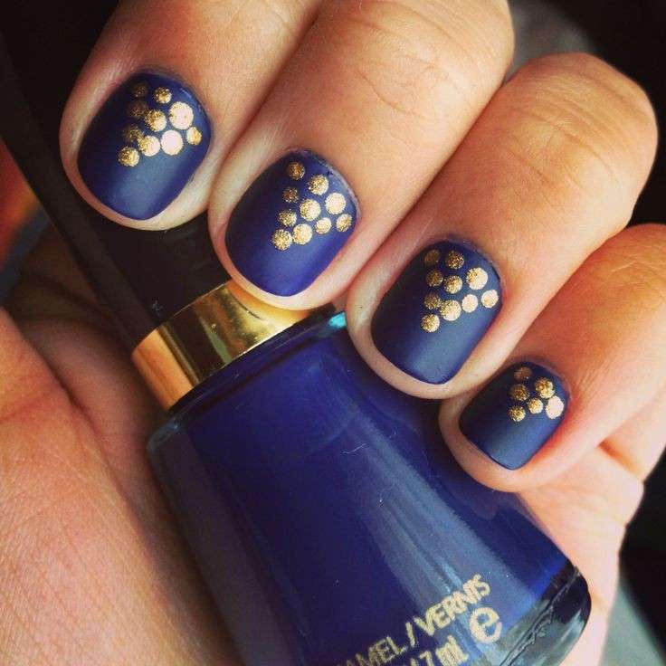 Nail art blu con pois oro