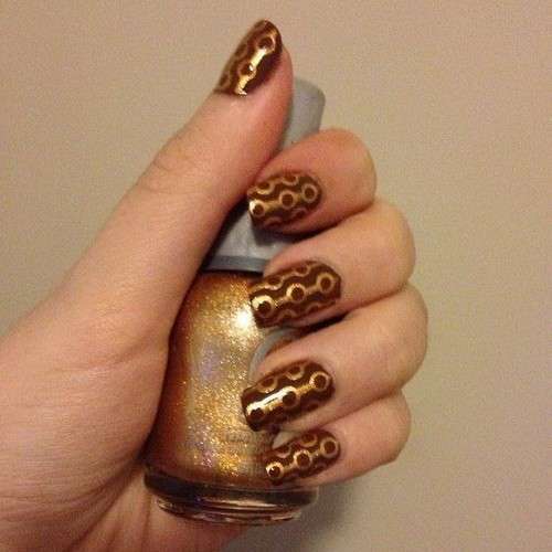 Nail art marrone con decorazioni oro