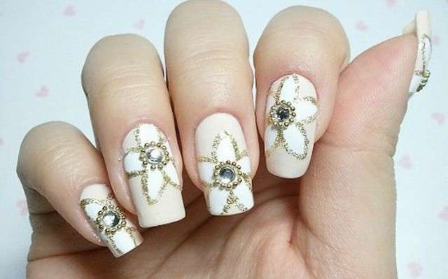 Nail art bianca con fiori di strass