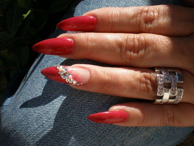 Nail art rossa con decorazioni preziose