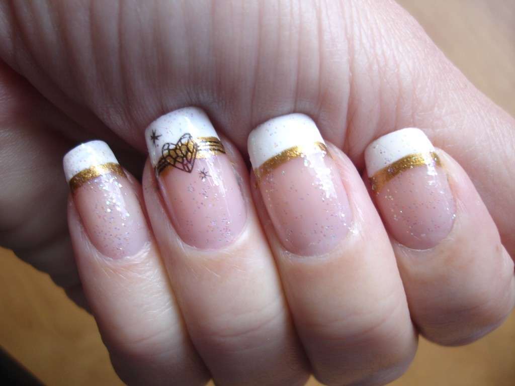 French manicure con dettagli oro e decorazioni