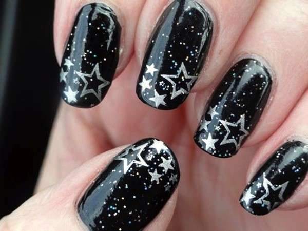 Nail art nera con stelle argentate