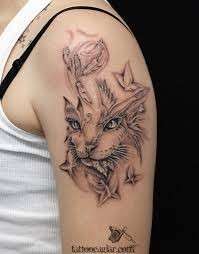 Il muso di un gatto tatuato sul braccio
