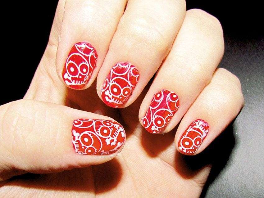 Nail art rossa con teschi stilizzati