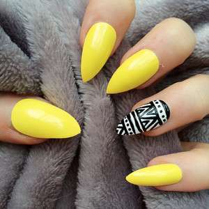 Nail art gialla con decorazione bianca e nera