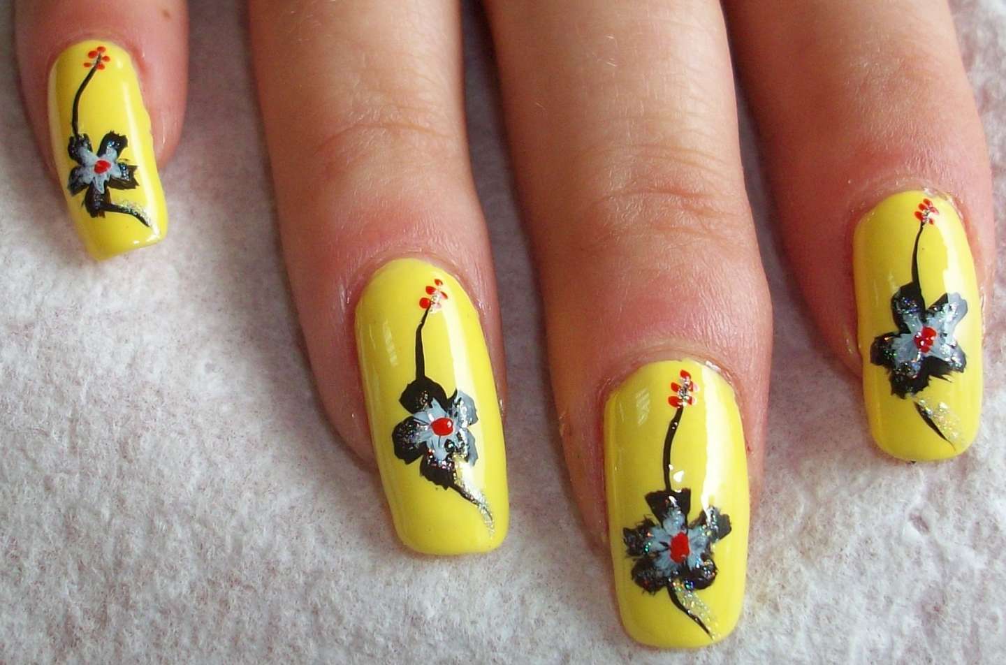 Nail art gialla con decorazioni floreali