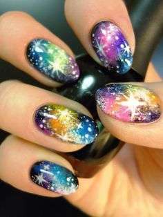 Nail art multicolor con stelle e pianeti