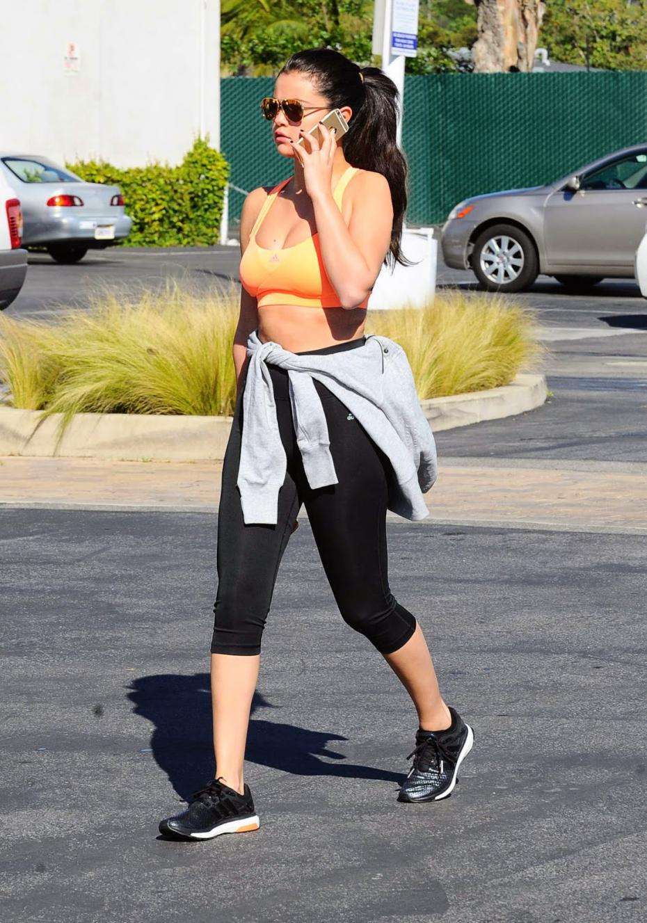 Selena Gomez con top arancione e leggings