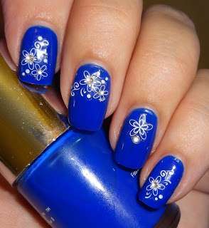 Nail art blu con decorazioni floreali
