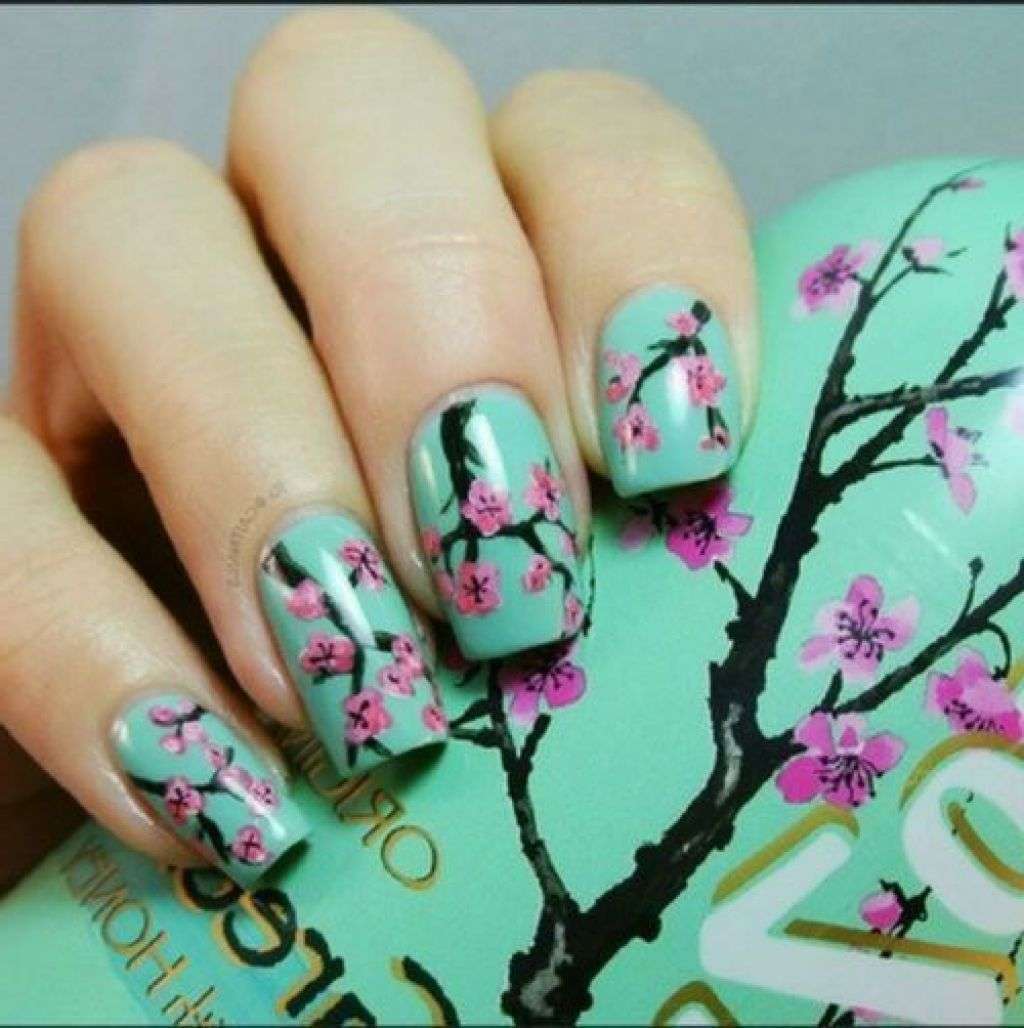 Nail art verde con fiori di ciliegio 