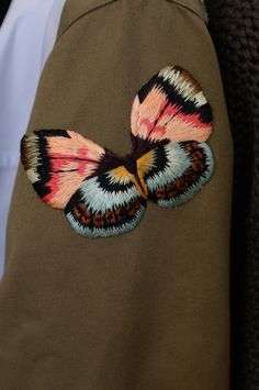 Toppa a forma di farfalla cucita sulla giacca