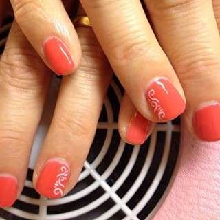 Nail art corallo con decorazioni bianche