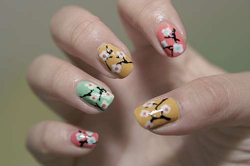 Nail art colorata con fiori di ciliegio